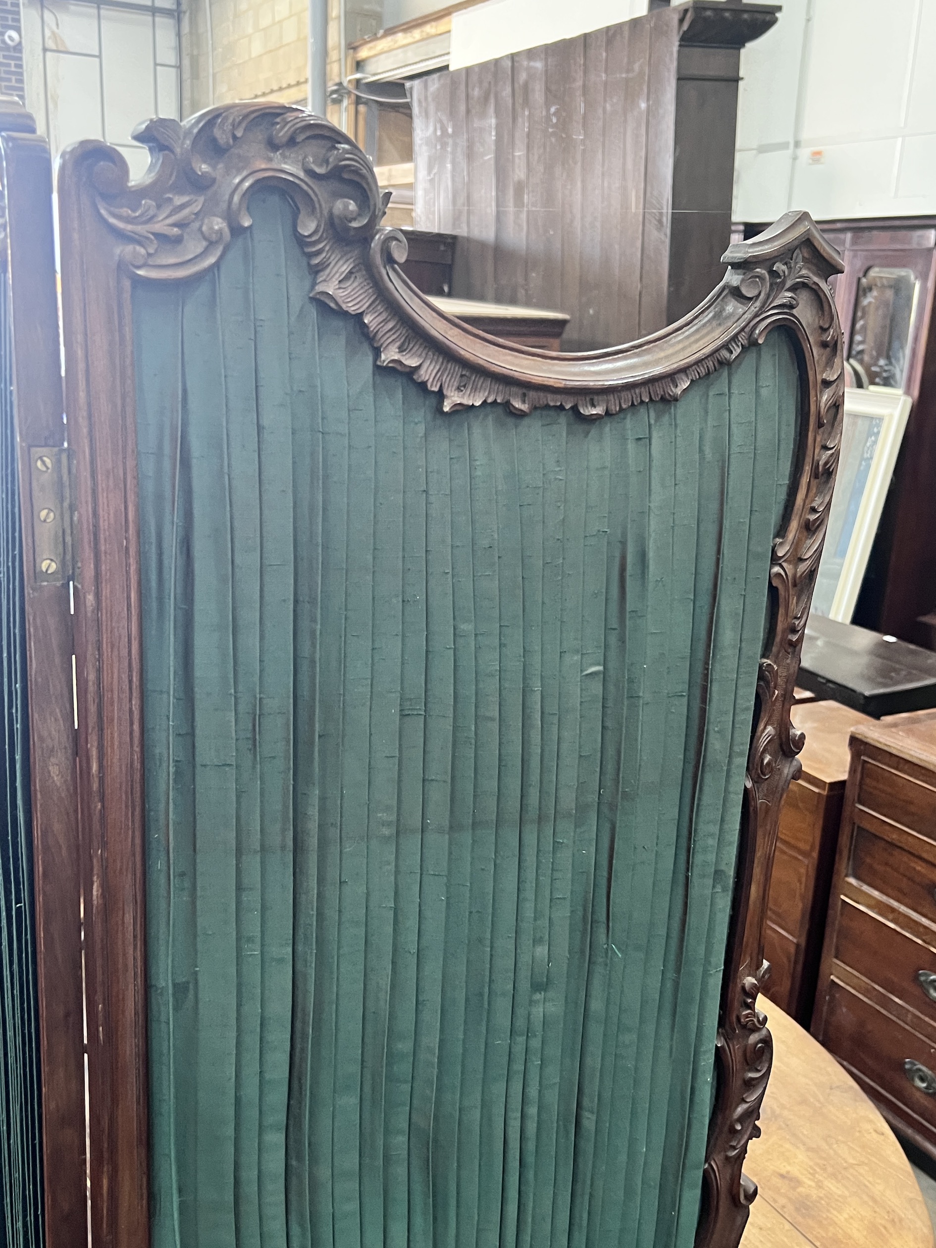 A small Victorian style mahogany two fold carved screen, each panel width 50cm, height 112cm